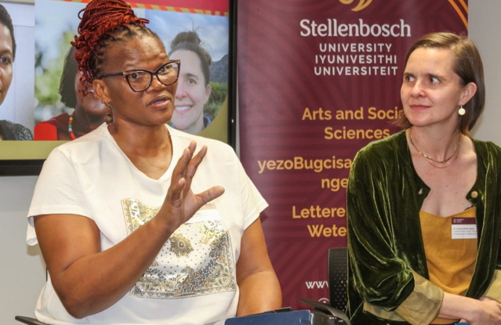 Thozama April (left), one of the organisers of We Need New Names, the 2025 ACIP 
	        Workshop, makes a point as co-organiser Sophia Sanan looks on. Photo by Jesse Le Roux.